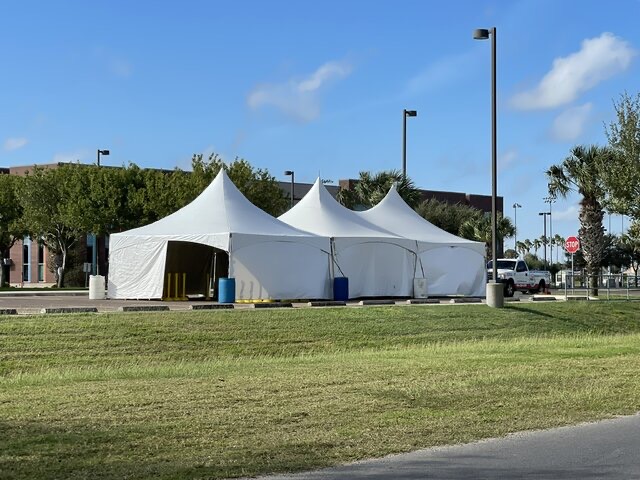 20 by 60 white pole tent set up on a lawn
