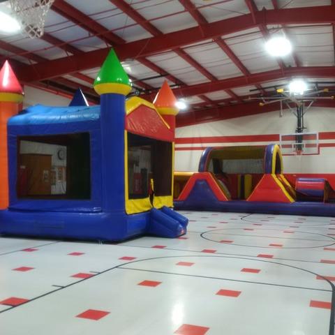 Castle bounce house and obstacle course set up inside an elementary school gym in Pharr
